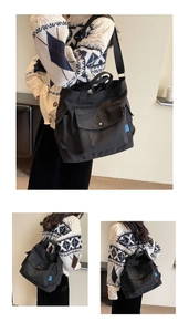 Detail of black canvas tote bag showing side pockets and adjustable shoulder strap
