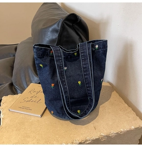 Detail einer dunkelblauen Denim-Tote-Bag mit bunter Tulpenstickerei auf Steinbasis