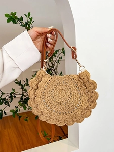 Woven straw shoulder bag with unique scalloped edges and leather strap for vacations