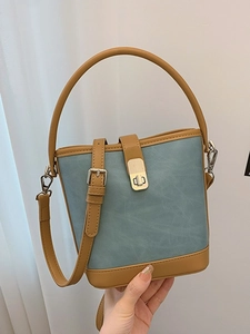 Contrast color bucket bag in blue and brown faux leather with silver metal buckle strap