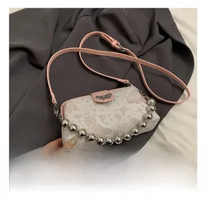 Detail showing pink sequin butterfly embroidery and silver bead chain on white crossbody bag