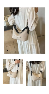 Détail du sac beige en toile avec lanières en cuir noir et imprimé RESTAIN OVERY