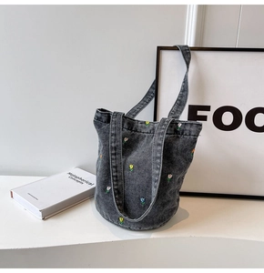 Detailansicht bunter Tulpenstickerei auf einer grauen Denim-Beuteltasche