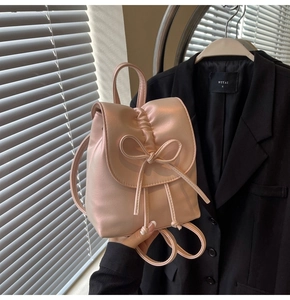 Détail du mini sac à dos rose à volants avec un nœud en satin et fermeture à cordon