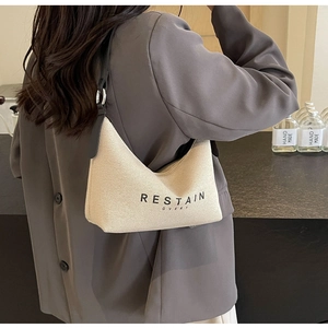 Détail d'un sac Hobo en toile beige avec bandoulière en cuir et imprimé RESTAIN