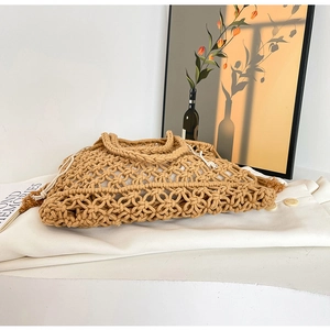 Detail of hollow woven shoulder bag with a white drawstring inner pouch for summer vacation