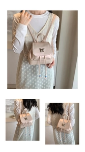Detail des rosa Mini-Rucksacks mit silberner Schmetterlingsschließe und Perlenband