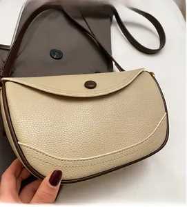 Detailed macro view of the lychee-textured leather and contrast stitching on the saddle bag