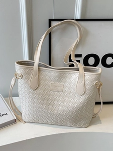 Minimalist cream woven tote bag with slim shoulder straps and spacious interior for daily use