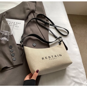 Détail du sac hobo en toile sur blazer gris avec bandoulière réglable en cuir et imprimé