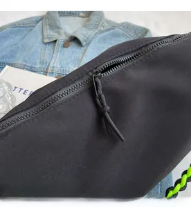 Detail shot of smooth metal zipper and woven puller on a black nylon shoulder bag