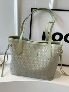 Chic light green woven tote bag with dual handles and stylish side drawstring details