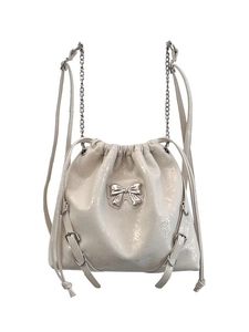 Chic cream white drawstring bucket bag with silver bow accent and metal chain straps