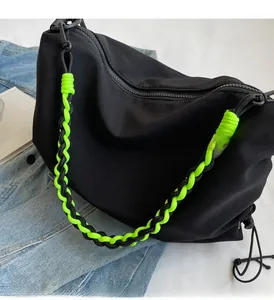 Detail of nylon bag with neon green woven rope handle and functional drawstring closure