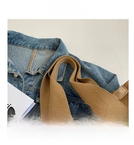 Close-up of khaki canvas tote bag showing thick woven straps and leather edging details
