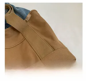 Detail of reinforced stitching and durable canvas texture on a khaki tote bag strap