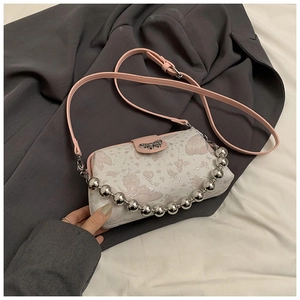 Close-up of white crossbody bag featuring pink butterfly embroidery and a silver bead chain
