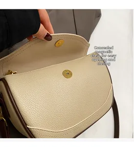 Detail of beige litchi grain leather bag showing hidden magnetic closure and gold hardware