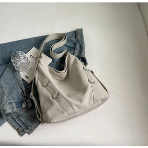 Nahaufnahme der beigen Canvas-Tasche mit verstellbarem Gurt und Metall-D-Ring
