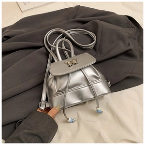 Nahaufnahme des silbernen Mini-Rucksacks mit goldener Schmetterlingsschnalle und Kordelzug