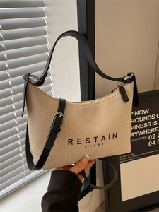Sac à main beige en toile avec bandoulière en cuir noir et lettrage artistique