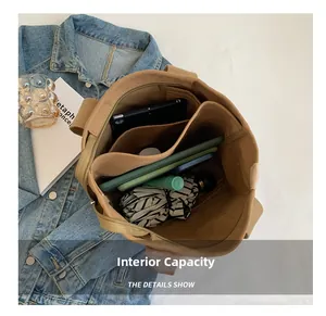 Flat lay of spacious khaki canvas tote bag interior showing multi-pocket storage layout