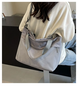 Detail of light gray mesh tote bag showing adjustable straps and breathable fabric