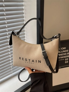 Sac à main beige en toile minimaliste avec lanières en cuir noir et détails