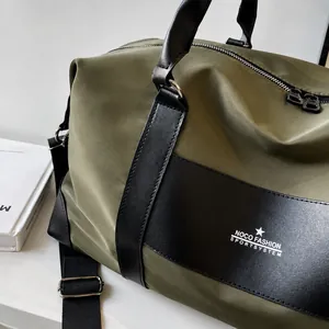 Close-up of army green travel bag showing nylon texture and fashion brand logo
