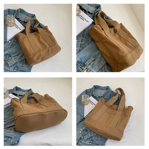 Detail view of large canvas tote bag with reinforced oval base and sturdy shoulder straps