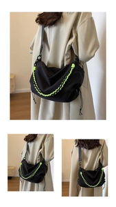 Detail of black nylon dumpling bag with vibrant green cords shown on a model