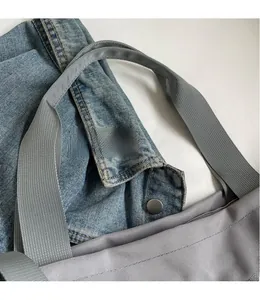 Detail of grey oxford fabric tote with reinforced handles and metallic snap button