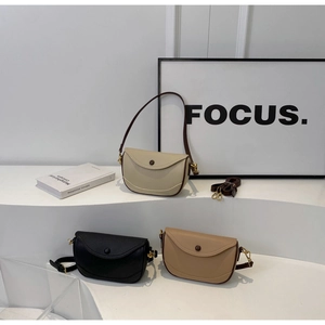 Detailed shot of three saddle bags in white, black and camel litchi grain leather