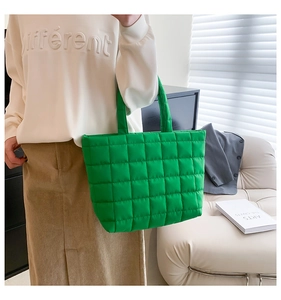 Detail of green quilted tote bag showing square stitching and padded nylon texture
