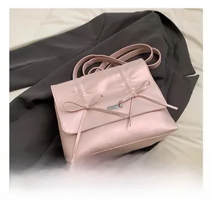 Detailed macro view of pink pearlescent leather bag with elegant bow accents