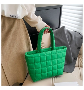 Detail of bright green quilted puffer tote bag held by a model in a modern home office