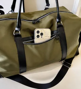 Close-up of olive green travel bag showing black zipper pocket and large interior capacity