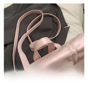 Detail of soft pink pleated handbag with comfortable handle and smooth faux leather texture