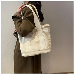 Detail of high-capacity canvas tote bag showing thick fabric texture and wide shoulder strap