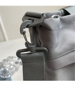 Detail of detachable grey plastic swivel hook on durable nylon canvas travel bag