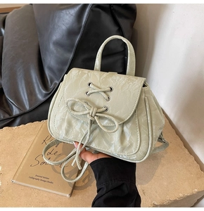 Dettaglio zaino verde chiaro arricciato con fiocco decorativo e occhielli argento