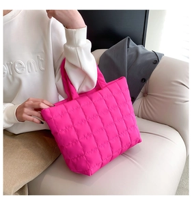 Detail of hot pink quilted nylon tote bag with puffer handles for casual daily wear
