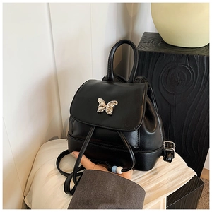 Detailansicht eines Mini-Rucksacks aus schwarzem PU-Leder mit Schmetterling-Metallstück