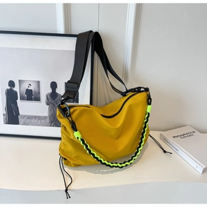 Detail of yellow nylon hobo bag featuring decorative neon woven chain and side drawstring