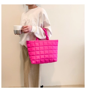 Detailed side view of high-capacity quilted tote bag in bright pink with soft padding