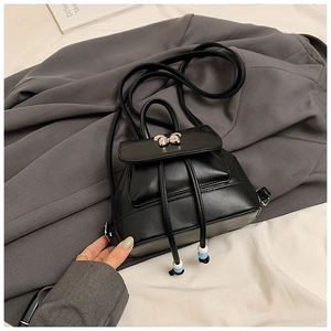 Detail eines schwarzen Mini-Rucksacks aus PU-Leder mit goldener Schleife und Kordelzug