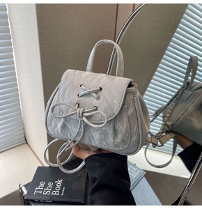 Dettaglio zaino grigio chiaro stile balletto con texture stropicciata e fiocco decorativo