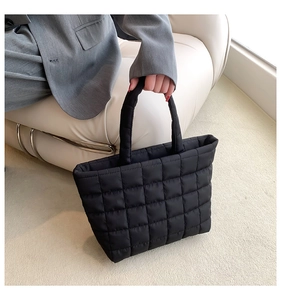 Close-up of black quilted cloud tote bag featuring high-density padded diamond stitching