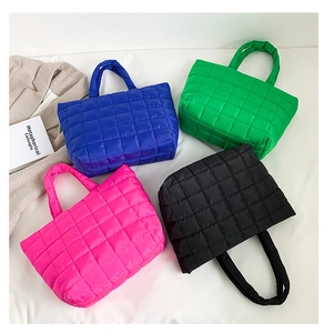 Close-up of quilted nylon tote bags in blue, green, pink, and black colors