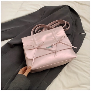 Detail of light pink bow backpack with metallic buckle on a dark grey blazer